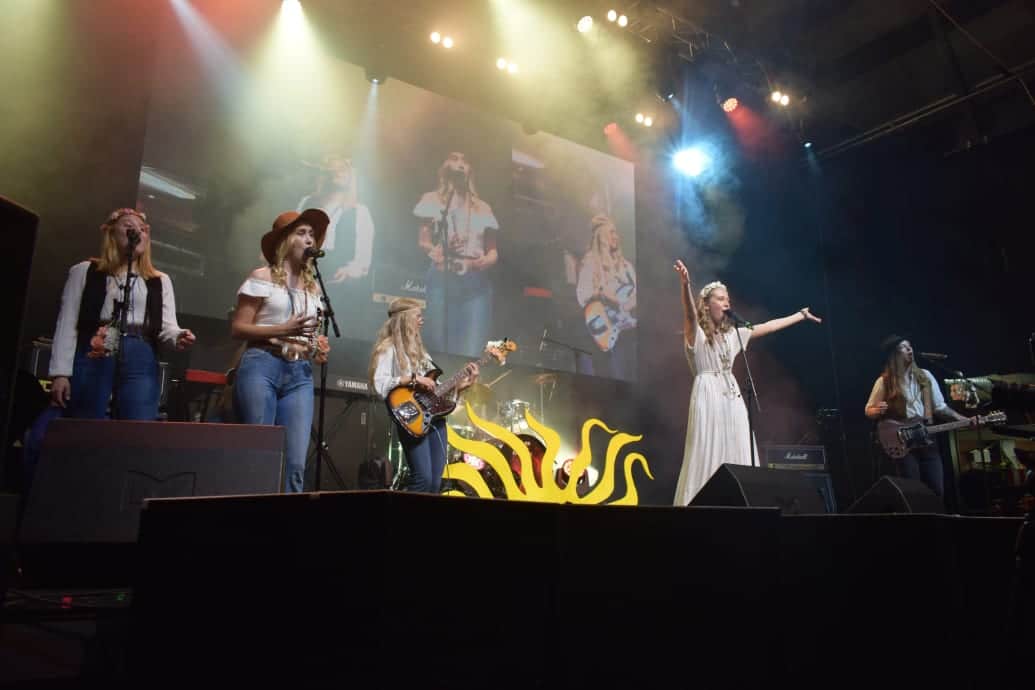 En scen med kvinnor i countrykläder som sjunger